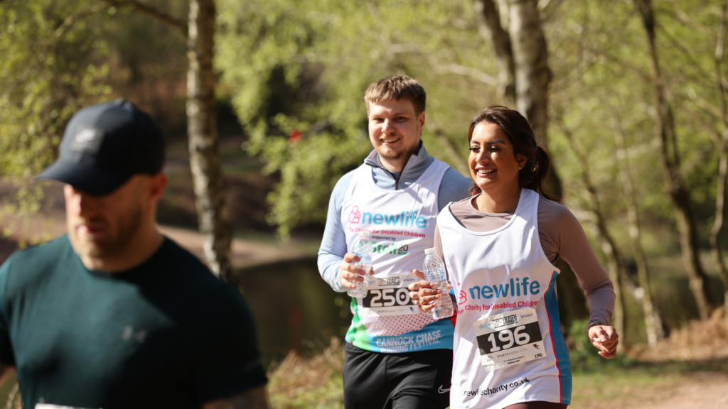 Two fundraisers for Newlife running in a green park.