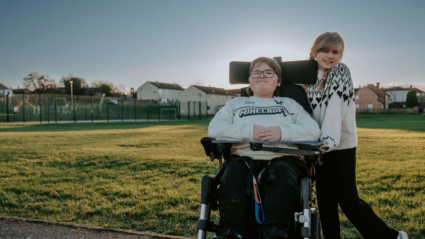 Picture of Laigan with her sister in the new powered wheelchair funded by Newlife