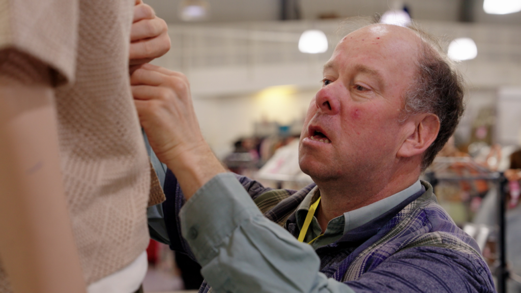 Image shows Retail volunteer tidying clothing rails in the Newlife superstore.