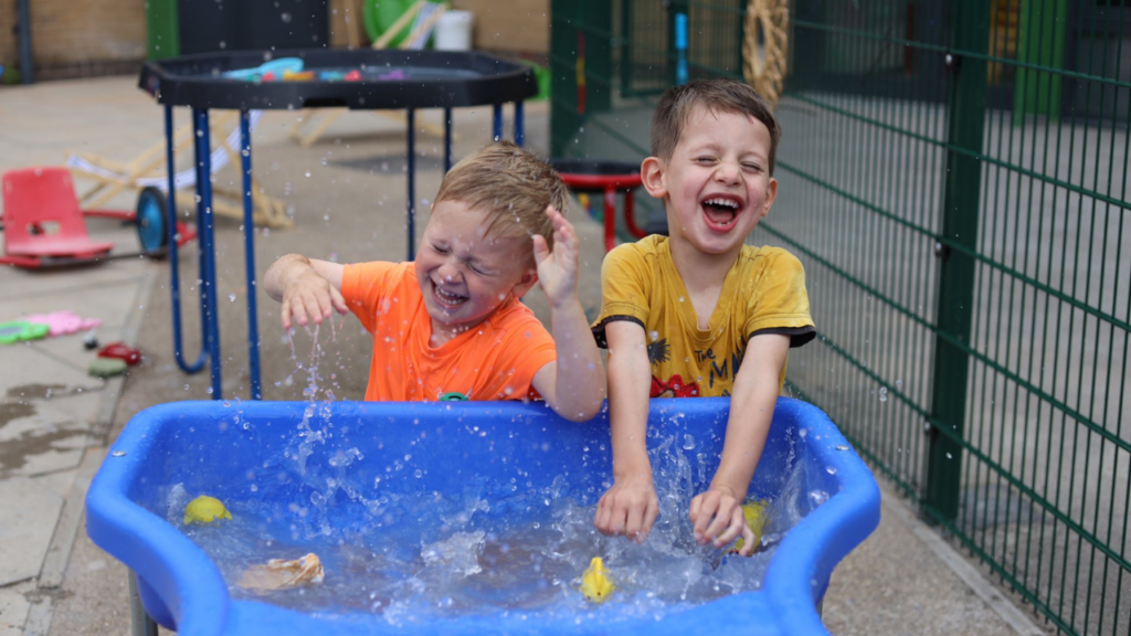 Boys playing in water trough