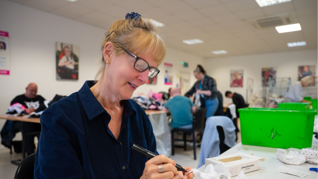 Picture shows a stock processing volunteer processing stock in the Newlife opportunities centre