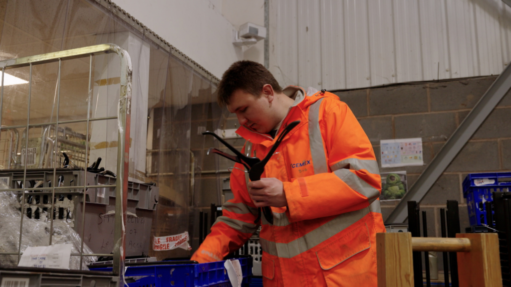 Picture shows a Newlife warehouse volunteer sorting coathangers in the warehouse