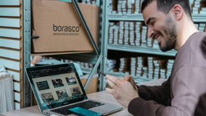 Picture shows a man working at a desk in a warehouse environment