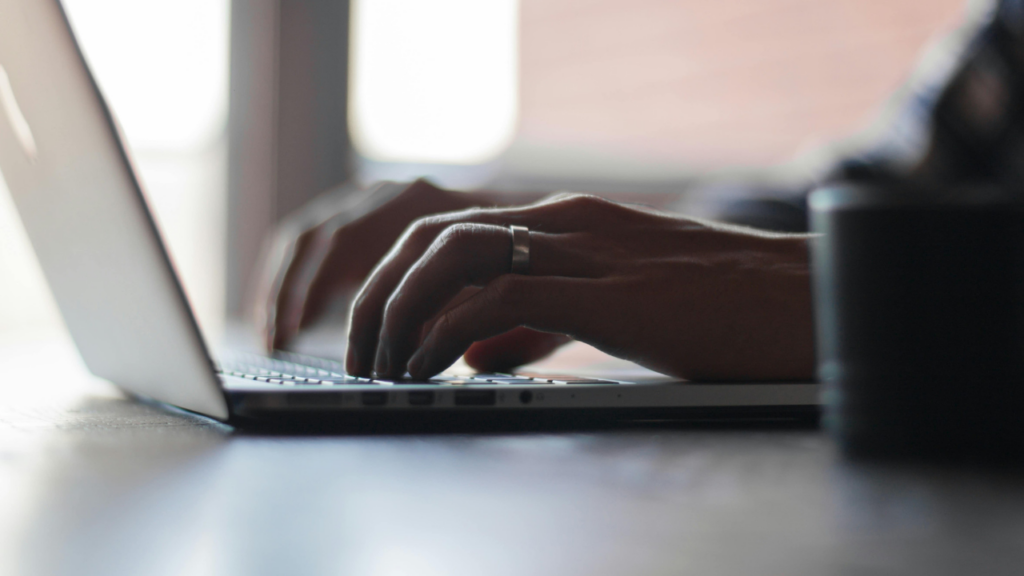 Image shows hands typing on laptop